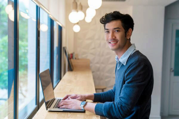 man typing on a laptop