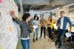 woman pointing to graphs on a whiteboard