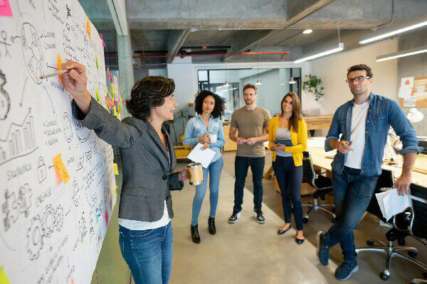 woman pointing to graphs on a whiteboard